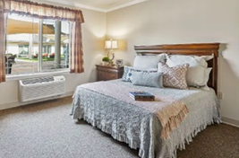 A bedroom with a bed, a window, a lamp, a dresser, and a heater. AI generated content